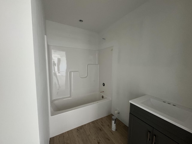 bathroom featuring shower / washtub combination, wood finished floors, and vanity