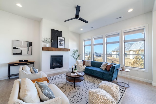 living area featuring light wood-style floors, baseboards, visible vents, and recessed lighting