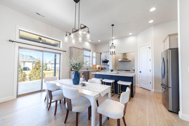 dining space featuring light wood-style flooring, visible vents, baseboards, and recessed lighting