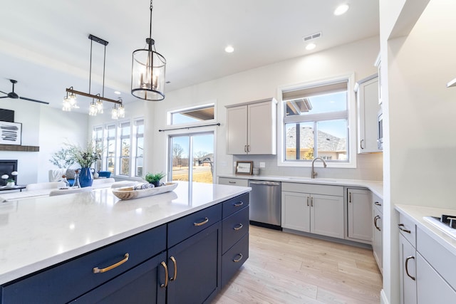 kitchen with a sink, tasteful backsplash, light countertops, and dishwasher