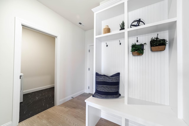 mudroom featuring visible vents, baseboards, and wood finished floors