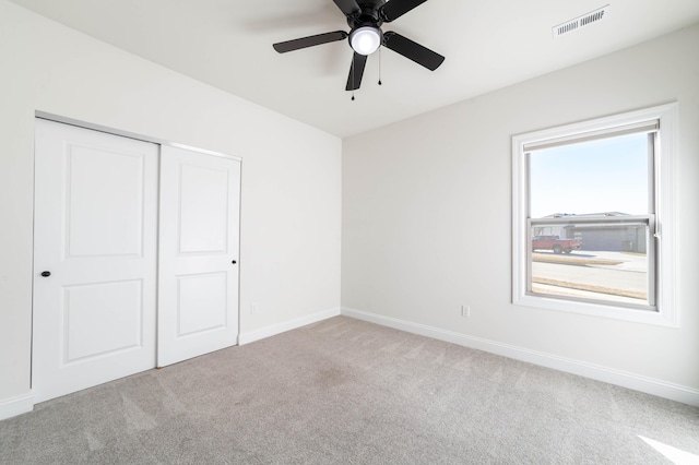 unfurnished bedroom with baseboards, a closet, visible vents, and carpet flooring