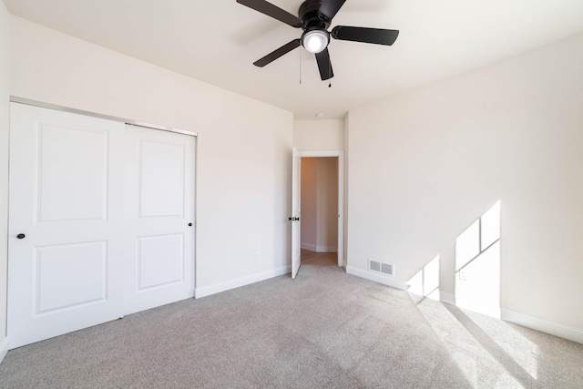 unfurnished bedroom with carpet floors, a closet, visible vents, and baseboards