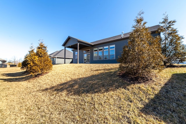 rear view of property featuring a yard