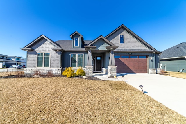 craftsman inspired home with board and batten siding, stone siding, a front lawn, and concrete driveway