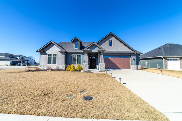 craftsman-style home with a garage, driveway, stone siding, a front lawn, and board and batten siding