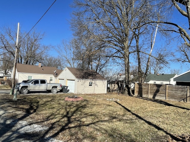 view of yard featuring a detached garage and fence