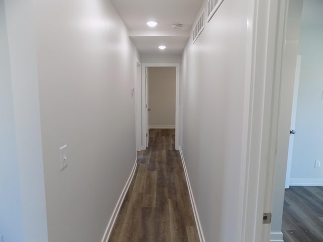 hallway featuring dark wood-style floors, recessed lighting, visible vents, and baseboards