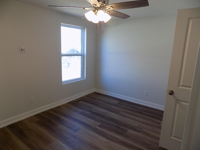 unfurnished room with a ceiling fan, baseboards, and dark wood-style flooring