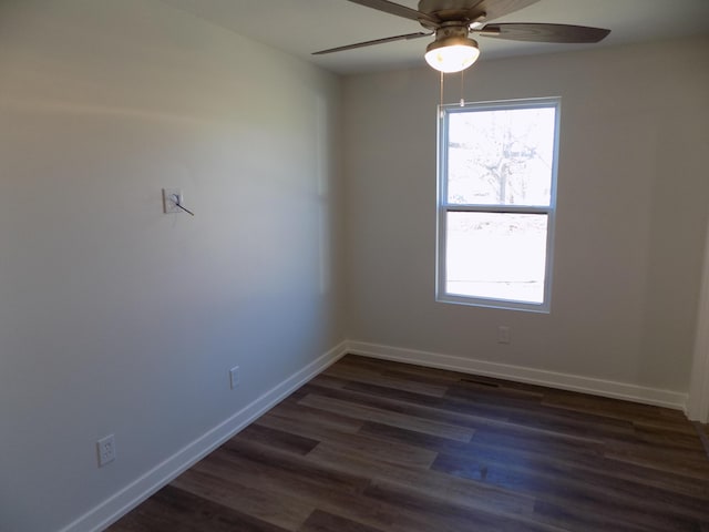 empty room featuring dark wood-style floors, baseboards, and a ceiling fan