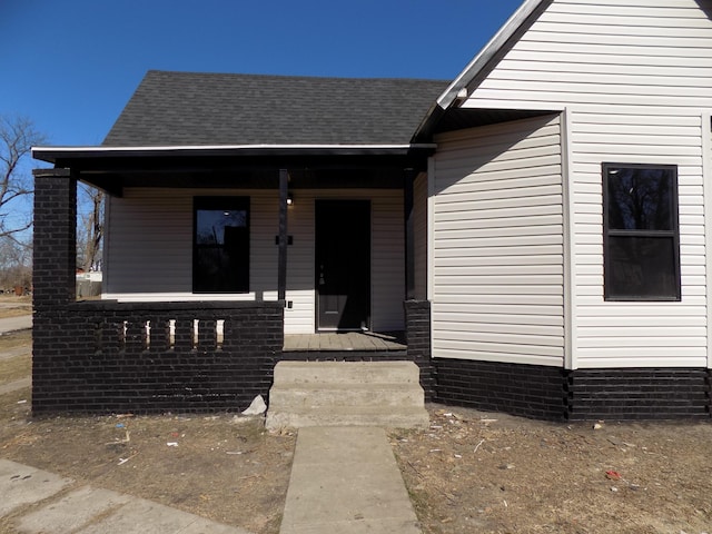 view of front of home with a porch and roof with shingles