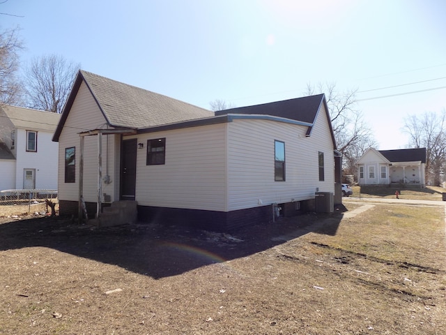 exterior space with entry steps, roof with shingles, and central air condition unit