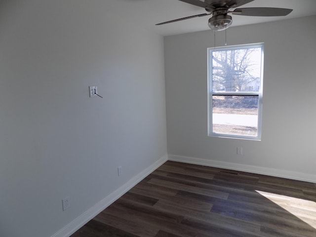 empty room featuring ceiling fan, dark wood finished floors, visible vents, and baseboards