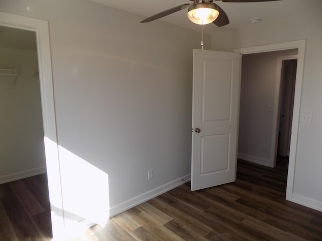 unfurnished bedroom with ceiling fan, wood finished floors, and baseboards