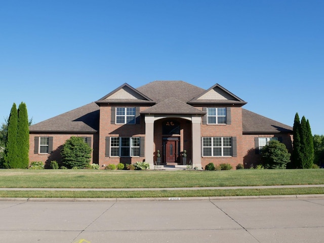 view of front of property featuring brick siding and a front yard