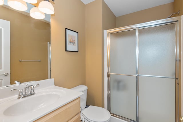 full bath featuring a shower with door, vanity, and toilet