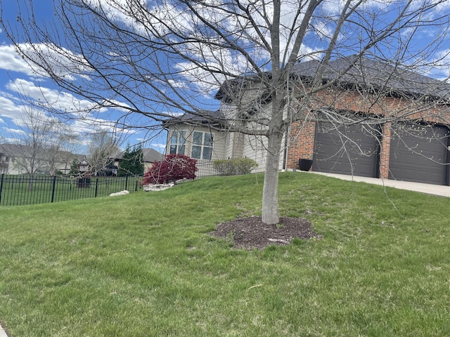 view of front of property with concrete driveway, a front lawn, fence, and brick siding