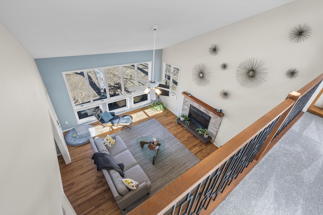 living room featuring ceiling fan, high vaulted ceiling, a brick fireplace, and wood finished floors