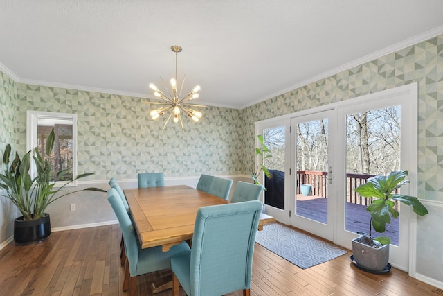 dining space with wallpapered walls, hardwood / wood-style floors, and crown molding