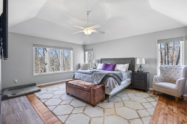 bedroom featuring baseboards, ceiling fan, a textured ceiling, and light wood-style floors