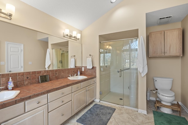 bathroom with lofted ceiling, a sink, a shower stall, and decorative backsplash