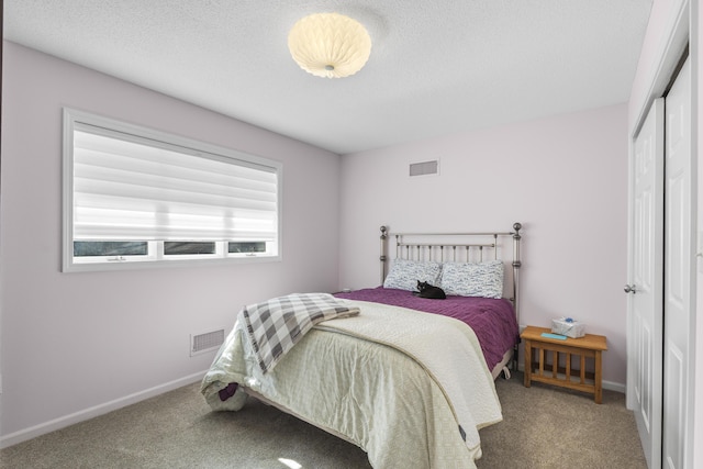 carpeted bedroom featuring a closet, visible vents, and baseboards