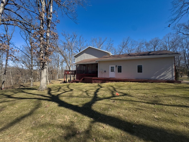 rear view of property with a sunroom, a deck, and a yard