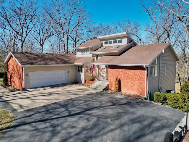 view of front of home with concrete driveway, brick siding, and an attached garage