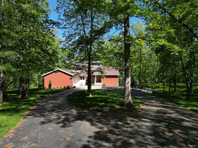 view of front of home featuring driveway, a garage, and a front yard