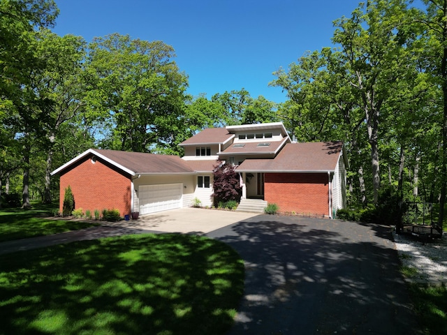 view of front of home with brick siding, concrete driveway, a garage, and a front lawn