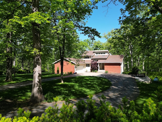 mid-century home with a front lawn, stucco siding, driveway, and a garage