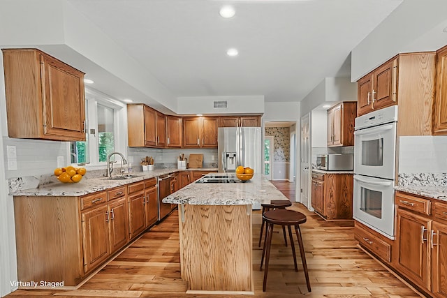 3700 S Joan Ct, Columbia, MO 65201 - kitchen featuring stainless steel appliances, light wood-type flooring, a kitchen island, healthy amount of natural light, and recessed lighting