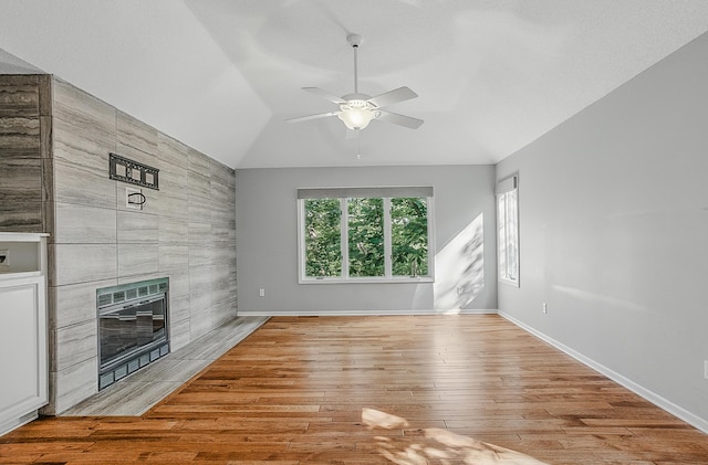 3700 S Joan Ct, Columbia, MO 65201 - unfurnished living room with a ceiling fan, vaulted ceiling, wood finished floors, a tiled fireplace, and heating unit