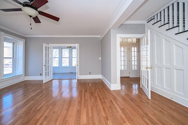 entryway with light wood finished floors, french doors, a healthy amount of sunlight, and crown molding