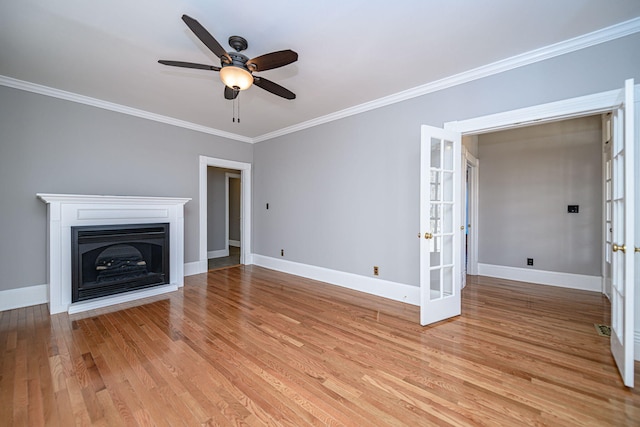 unfurnished living room with a fireplace, baseboards, light wood-style floors, french doors, and ornamental molding