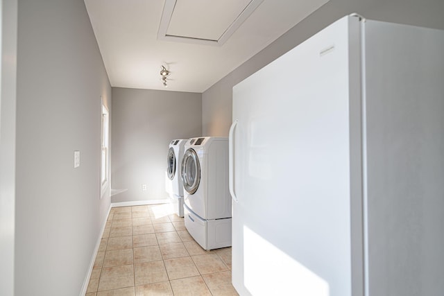 laundry room featuring light tile patterned floors, rail lighting, washer and dryer, laundry area, and baseboards