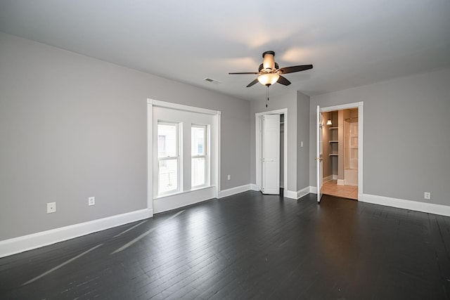 spare room with ceiling fan, dark wood-style flooring, visible vents, and baseboards