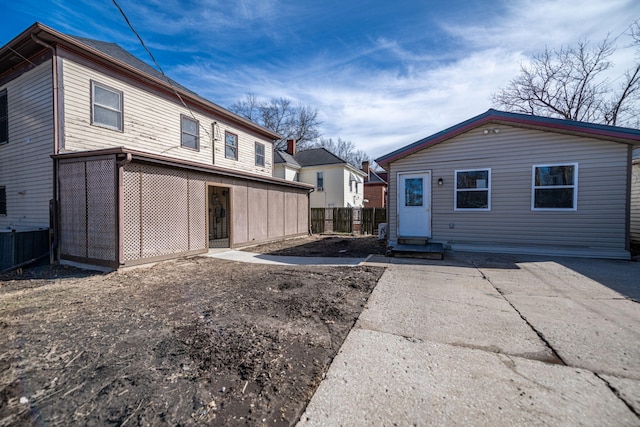 back of property featuring entry steps and fence