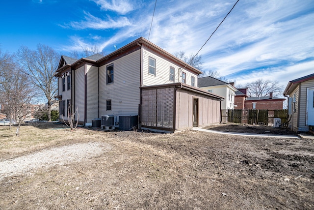 view of side of property featuring fence and central AC