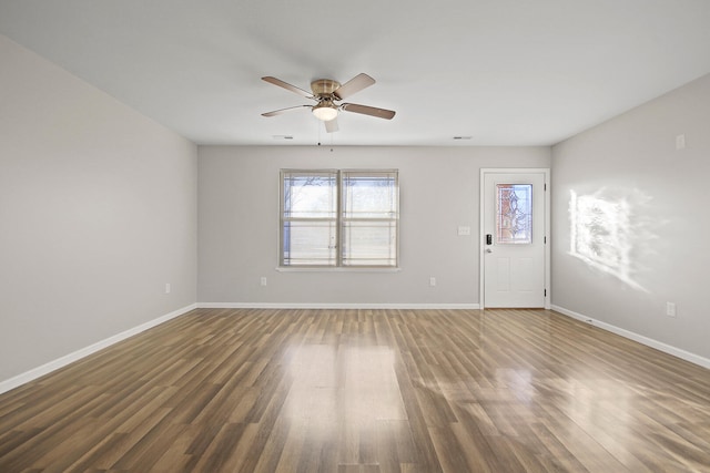 interior space with ceiling fan, wood finished floors, and baseboards