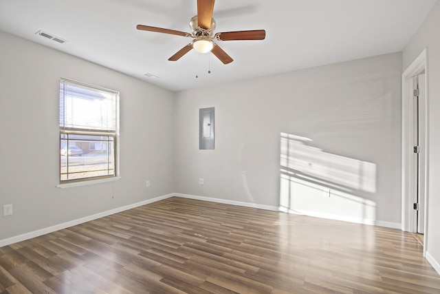 spare room with ceiling fan, wood finished floors, visible vents, baseboards, and electric panel