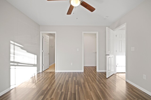 unfurnished bedroom featuring a spacious closet, a closet, and wood finished floors