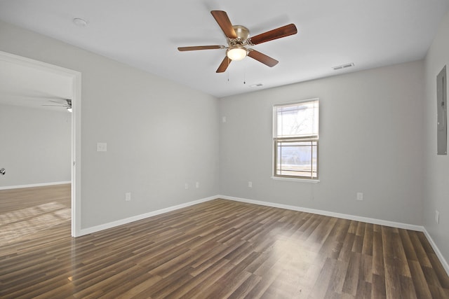 empty room featuring ceiling fan, wood finished floors, visible vents, and baseboards