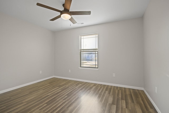 empty room featuring wood finished floors, a ceiling fan, and baseboards