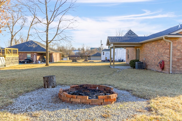 view of yard with an outdoor fire pit and central AC unit