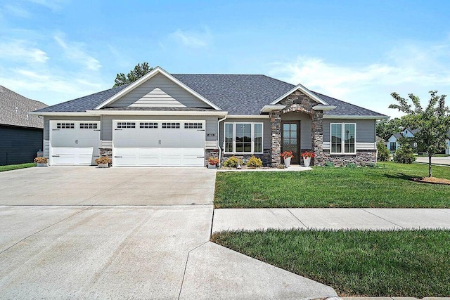 craftsman-style house featuring driveway, a garage, a shingled roof, stone siding, and a front yard