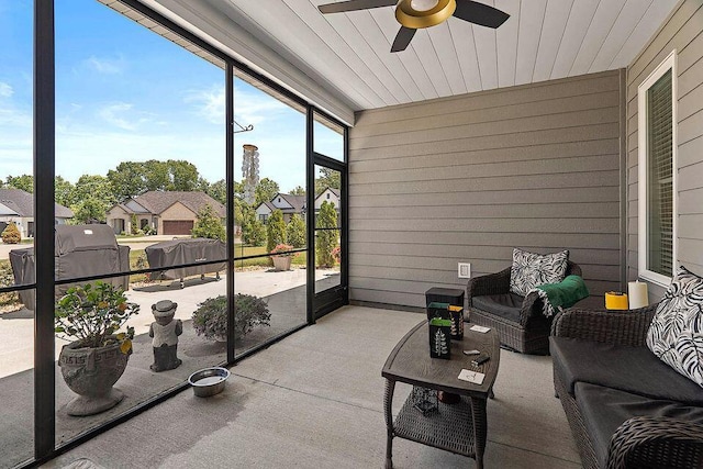 sunroom featuring wood ceiling and a ceiling fan