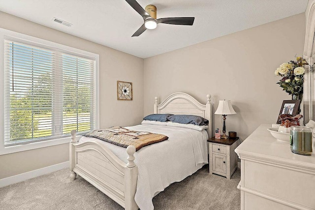 bedroom featuring baseboards, visible vents, ceiling fan, and light colored carpet