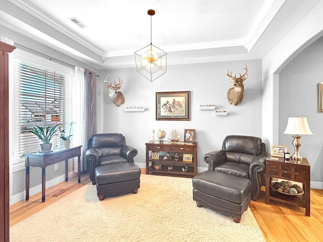 living area with arched walkways, wood finished floors, visible vents, and crown molding