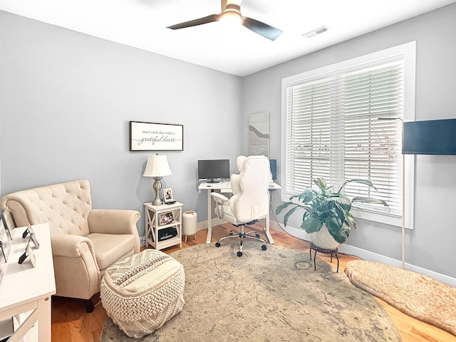 office space with ceiling fan, wood finished floors, visible vents, and baseboards